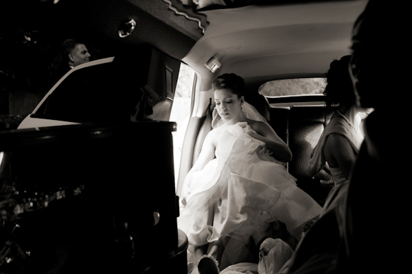 photo by New York based wedding photographer Merri Cry - Beautiful black and white photo of bride getting in to the limousine 
